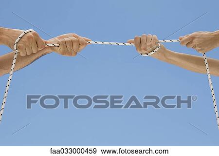 Stock Photo - Hands playing tug-of-war with rope. Fotosearch
