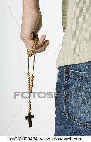 Picture - Male holding rosary, cropped rear view. Fotosearch