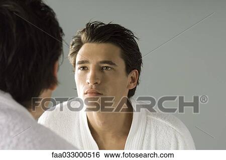 Man examining his face in the mirror, wearing bathrobe View Large Photo Image Stock Photograph - Man examining his face in the mirror, wearing bathrobe. Fotosearch