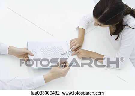 Man holding document, woman carefully reading it, high angle view View Large Photo Image Stock Image - Man holding document, woman carefully reading it, high angle view. Fotosearch