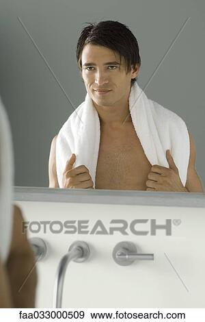 Man looking at self in mirror, holding towel on his shoulders View Large Photo Image Stock Photo - Man looking at self in mirror, holding towel on his shoulders. Fotosearch
