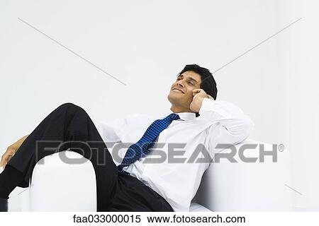 Man reclining in armchair, holding head, smiling View Large Photo Image Stock Photography - Man reclining in armchair, holding head, smiling. Fotosearch