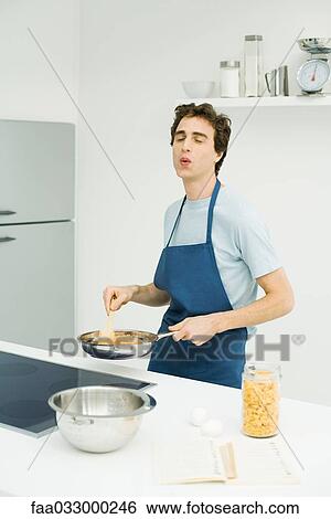 Man standing at stove, cooking, eyes closed, whistling View Large Photo Image Stock Photograph - Man standing at stove, cooking, eyes closed, whistling. Fotosearch
