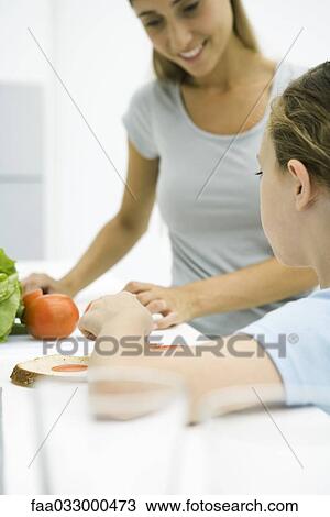 Mother and daughter preparing food together, cropped view View Large Photo Image Stock Image - Mother and daughter preparing food together, cropped view. Fotosearch