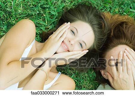 Mother and teen daughter lying together in grass, hands on face View Large Photo Image Stock Image - Mother and teen daughter lying together in grass, hands on face. Fotosearch