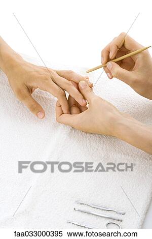 Stock Photography - Person receiving manicure, cropped view of hands. Fotosearch