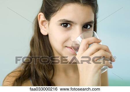 Teen girl drinking glass of water, smiling at camera View Large Photo Image Stock Photograph - Teen girl drinking glass of water, smiling at camera. Fotosearch