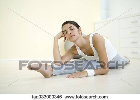 Woman doing split, holding head, eyes closed View Large Photo Image Stock Photograph - Woman doing split, holding head, eyes closed. Fotosearch