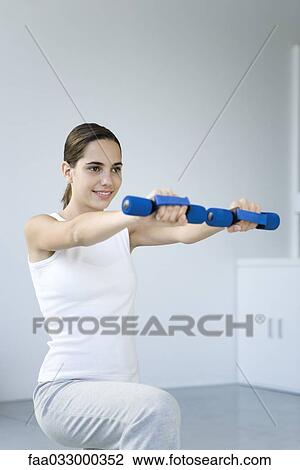 Woman exercising with dumbbells View Large Photo Image Stock Image - Woman exercising with dumbbells. Fotosearch