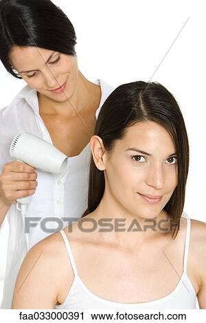 Woman having hair dried by stylist, smiling at camera View Large Photo Image Stock Image - Woman having hair dried by stylist, smiling at camera. Fotosearch