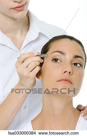 Woman having her eyebrows tweezed View Large Photo Image Picture - Woman having her eyebrows tweezed. Fotosearch