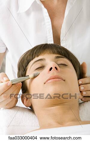 Picture - Woman having make-up applied, eyes closed. Fotosearch