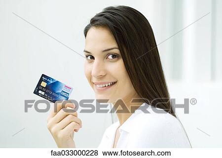 Woman holding credit card, smiling at camera View Large Photo Image Stock Photo - Woman holding credit card, smiling at camera. Fotosearch