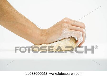 Stock Photo - Woman kneading dough, cropped view of hands, close-up. Fotosearch