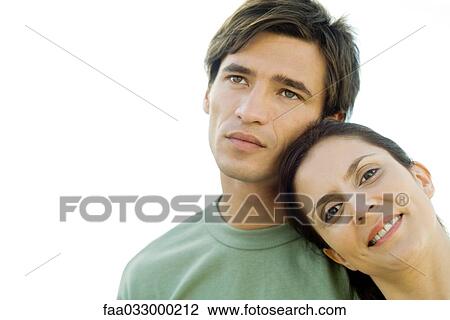 Stock Image - Woman leaning head against man's shoulder, smiling at camera. Fotosearch