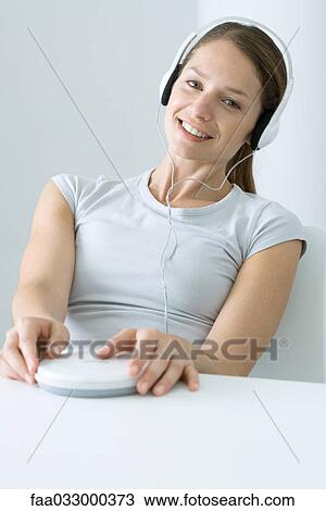 Woman listening to CD player with headphones, smiling at camera View Large Photo Image Stock Image - Woman listening to CD player with headphones, smiling at camera. Fotosearch