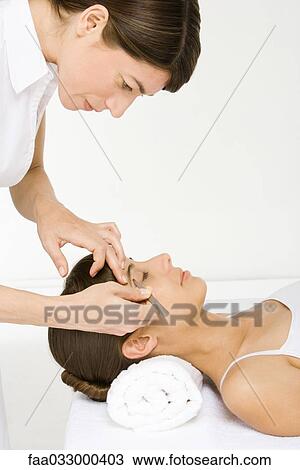 Woman lying on back, having eyebrows tweezed, side view View Large Photo Image Stock Image - Woman lying on back, having eyebrows tweezed, side view. Fotosearch