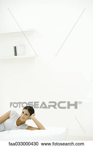 Woman lying on side, holding head, smiling at camera View Large Photo Image Stock Image - Woman lying on side, holding head, smiling at camera. Fotosearch