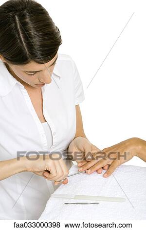 Stock Photo - Woman performing a manicure, cropped view. Fotosearch