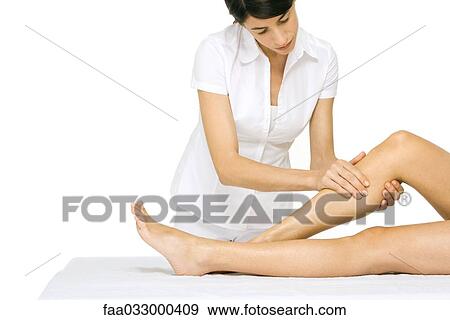 Stock Photo - Woman performing leg massage. Fotosearch