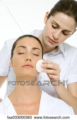 Stock Image - Woman receiving facial, eyes closed. Fotosearch