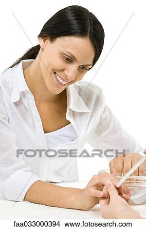 Picture - Woman receiving manicure. Fotosearch