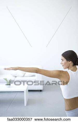 Woman stretching, one arm extended, side view View Large Photo Image Stock Photo - Woman stretching, one arm extended, side view. Fotosearch