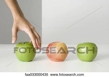 Woman's hand selecting apple View Large Photo Image Stock Photography - Woman's hand selecting apple. Fotosearch