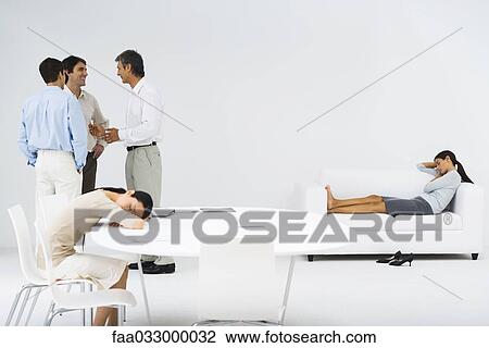 Women napping, one at table, one on couch, men talking in group in the corner View Large Photo Image Stock Image - Women napping, one at table, one on couch, men talking in group in the corner. Fotosearch