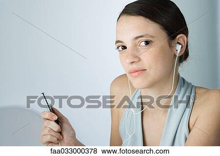 Young woman listening to MP3 player, portrait View Large Photo Image Stock Photo - Young woman listening to MP3 player, portrait. Fotosearch
