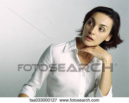 Young woman looking away, hand under chin, portrait View Large Photo Image Stock Photo - Young woman looking away, hand under chin, portrait. Fotosearch