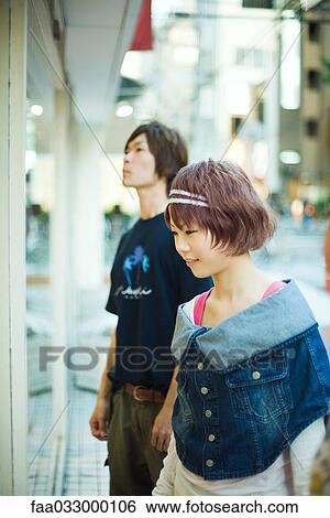 Young woman window shopping, man in background View Large Photo Image Stock Photograph - Young woman window shopping, man in background. Fotosearch