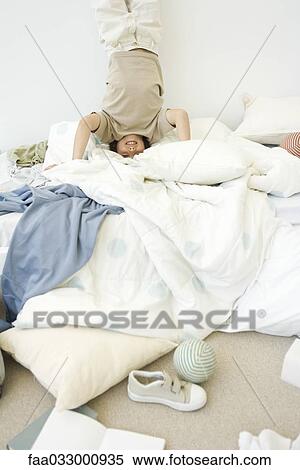 Boy doing handstand on bed in messy room View Large Photo Image Stock Photography - Boy doing handstand on bed in messy room. Fotosearch