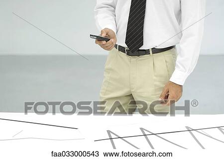 Businessman using cell phone, cropped view of mid section View Large Photo Image Stock Image - Businessman using cell phone, cropped view of mid section. Fotosearch