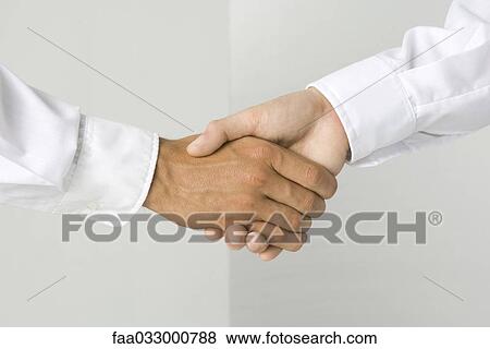 Stock Photo - Cropped view of a handshake. Fotosearch