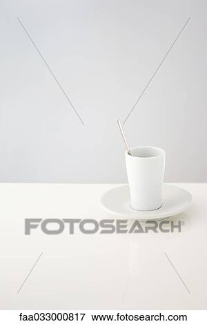 Stock Photo - Cup resting on saucer, spoon in cup. Fotosearch