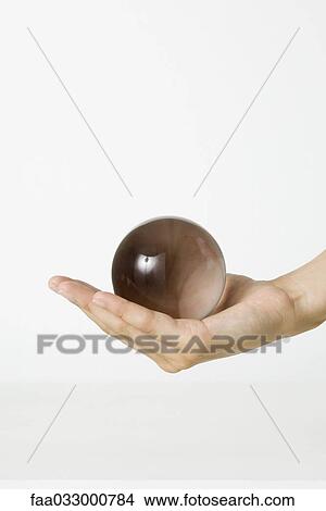Cupped hand holding crystal ball, cropped view View Large Photo Image Picture - Cupped hand holding crystal ball, cropped view. Fotosearch