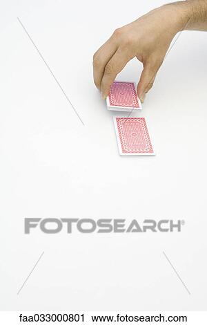 Stock Image - Hand cutting a deck of cards, cropped view. Fotosearch