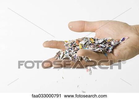 Stock Image - Hand holding confetti, cropped view. Fotosearch