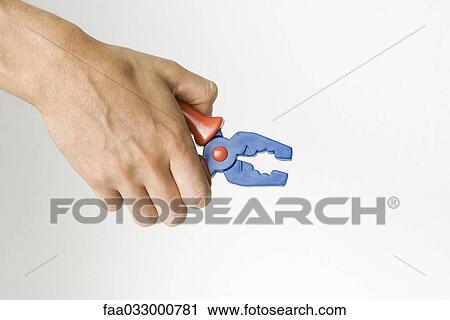 Hand holding toy pliers, cropped view View Large Photo Image Stock Image - Hand holding toy pliers, cropped view. Fotosearch