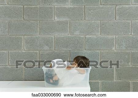Little boy sitting inside plastic storage container, side view View Large Photo Image Stock Image - Little boy sitting inside plastic storage container, side view. Fotosearch