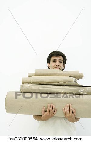 Man carrying stack of corrugated cardboard, looking at camera View Large Photo Image Picture - Man carrying stack of corrugated cardboard, looking at camera. Fotosearch