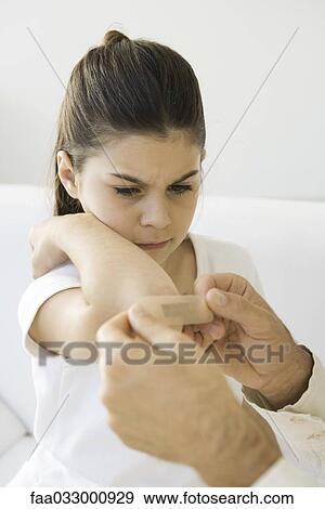 Man putting adhesive bandage on girl's elbow, cropped view View Large Photo Image Stock Photo - Man putting adhesive bandage on girl's elbow, cropped view. Fotosearch