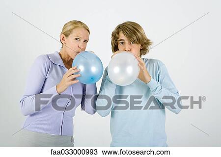 Mother and teen son standing side by side, inflating balloons, looking at camera View Large Photo Image Stock Image - Mother and teen son standing side by side, inflating balloons, looking at camera. Fotosearch