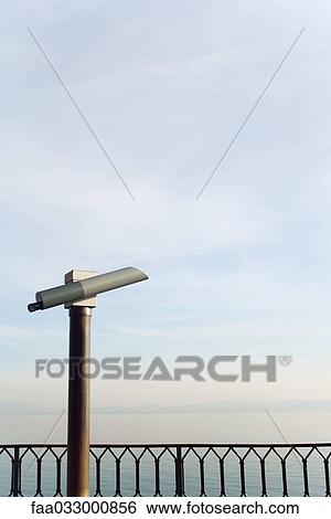Pay binoculars looking over railing at horizon over water View Large Photo Image Stock Photograph - Pay binoculars looking over railing at horizon over water. Fotosearch