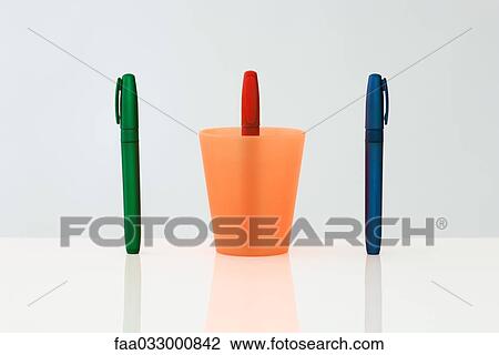 Pens standing upright in a row, the middle pen upside down inside of cup View Large Photo Image Stock Image - Pens standing upright in a row, the middle pen upside down inside of cup. Fotosearch