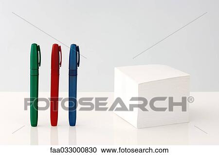 Stack of adhesive notes, multicolored pens standing in a row nearby View Large Photo Image Stock Image - Stack of adhesive notes, multicolored pens standing in a row nearby. Fotosearch