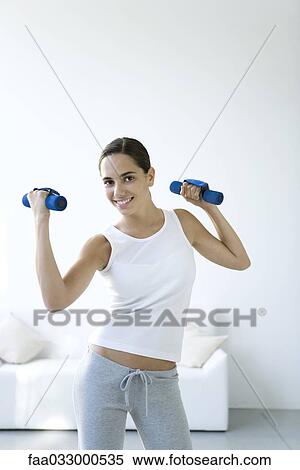Teen girl lifting dumbbells, smiling at camera View Large Photo Image Stock Photography - Teen girl lifting dumbbells, smiling at camera. Fotosearch