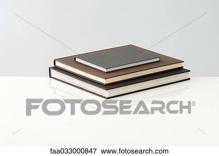 Three books stacked in a pyramid View Large Photo Image Stock Photo - Three books stacked in a pyramid. Fotosearch