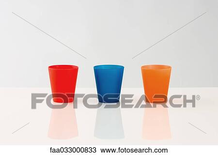 Three cups lined up in a row, multicolored View Large Photo Image Stock Image - Three cups lined up in a row, multicolored. Fotosearch